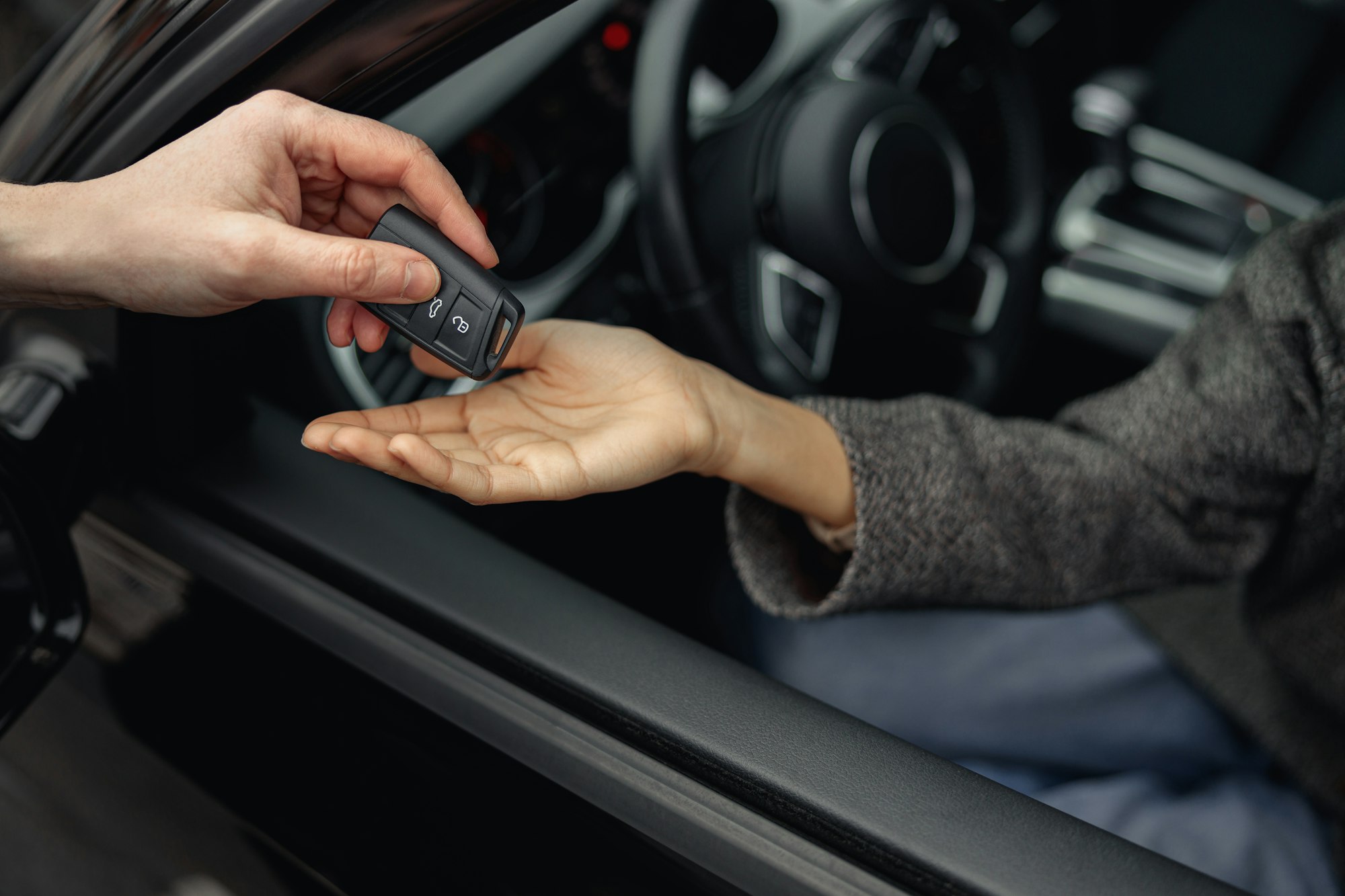Car dealer giving keys to female customer. Rent or purchase of auto - concept